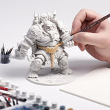 Using a Kolinsky Sable Detail Brush to paint intricate armor details on a large resin giant miniature model.