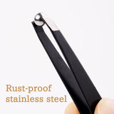 Tweezers holding a stainless steel mixing ball.