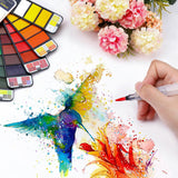 Hand-painting vibrant hummingbird artwork with portable travel watercolor paints and water brush.
