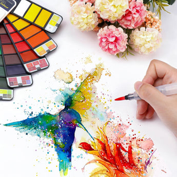 Hand-painting vibrant hummingbird artwork with portable travel watercolor paints and water brush.
