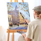 Artist painting vibrant cityscape watercolor artwork on an easel, holding a premium art brush and palette.