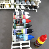 Various colored model paint dropper bottles organized neatly within a white acrylic storage rack.